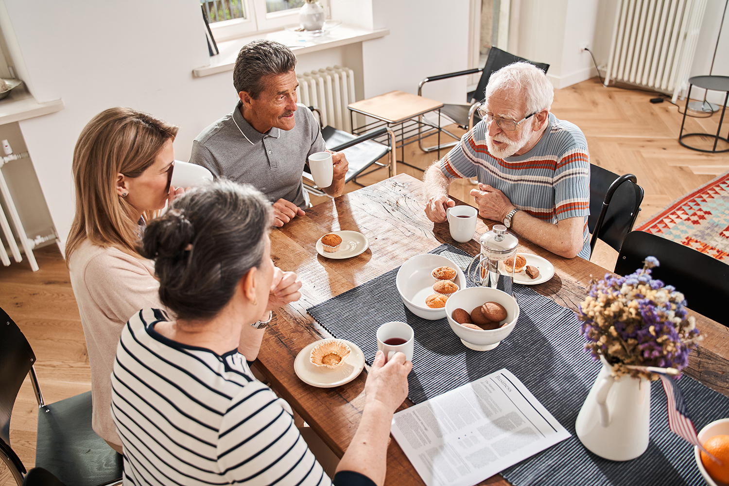 People having tea break with each other and chatting with their nurse at retirement home